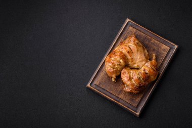 Lezzetli ızgara tavuk budu ya da koyu beton arka planda tuz ve baharatlı çeyreklik.