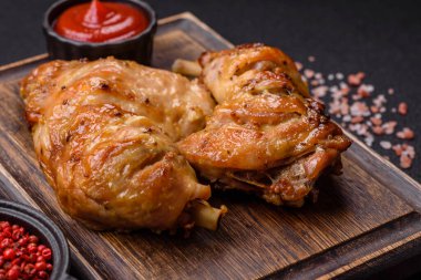 Lezzetli ızgara tavuk budu ya da koyu beton arka planda tuz ve baharatlı çeyreklik.