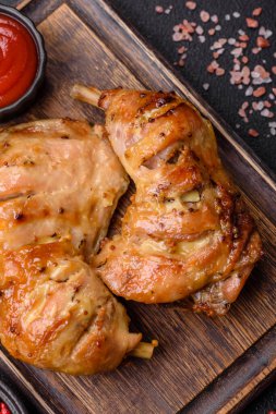 Lezzetli ızgara tavuk budu ya da koyu beton arka planda tuz ve baharatlı çeyreklik.