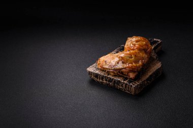 Lezzetli ızgara tavuk budu ya da koyu beton arka planda tuz ve baharatlı çeyreklik.