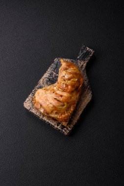 Lezzetli ızgara tavuk budu ya da koyu beton arka planda tuz ve baharatlı çeyreklik.