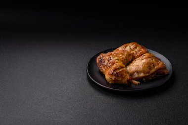 Lezzetli ızgara tavuk budu ya da koyu beton arka planda tuz ve baharatlı çeyreklik.