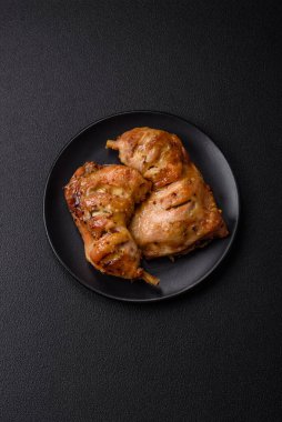 Lezzetli ızgara tavuk budu ya da koyu beton arka planda tuz ve baharatlı çeyreklik.