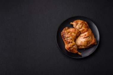 Lezzetli ızgara tavuk budu ya da koyu beton arka planda tuz ve baharatlı çeyreklik.