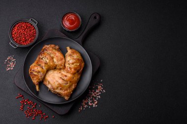 Lezzetli ızgara tavuk budu ya da koyu beton arka planda tuz ve baharatlı çeyreklik.