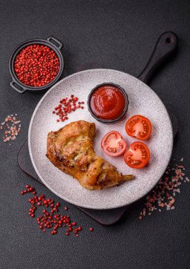 Lezzetli ızgara tavuk budu ya da koyu beton arka planda tuz ve baharatlı çeyreklik.