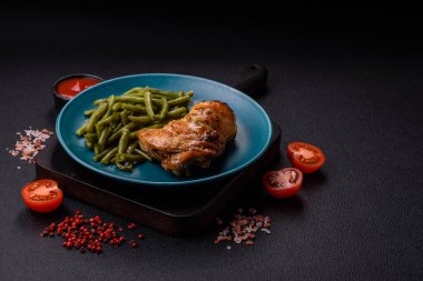 Lezzetli ızgara tavuk budu ya da koyu beton arka planda tuz ve baharatlı çeyreklik.