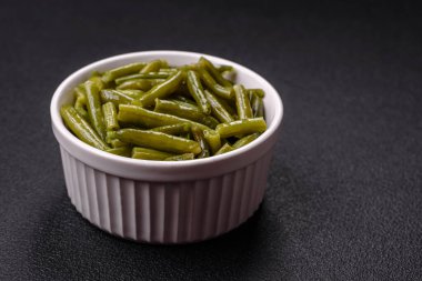 Koyu beton zeminde tuzlu ve baharatlı haşlanmış yeşil fasulye kabukları.