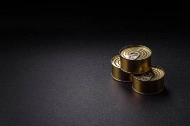 Yuvarlak metal teneke kutu konserve et ya da anahtar ile koyu beton arka planda açmak için balık.