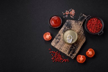 Yuvarlak metal teneke kutu konserve et ya da anahtar ile koyu beton arka planda açmak için balık.