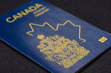 Koyu beton arka planda bir Kanada vatandaşının uluslararası pasaportu.