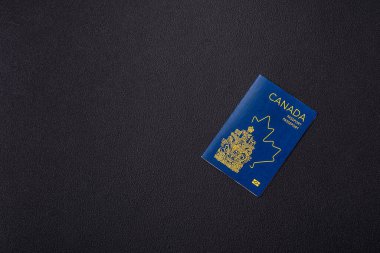 Koyu beton arka planda bir Kanada vatandaşının uluslararası pasaportu.