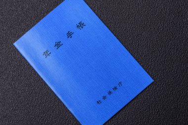 Emeklilik defteri ya da koyu beton arka planda Japon vatandaşı kimliği