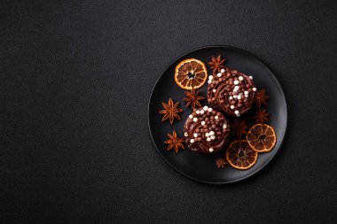 Doldurulmuş lezzetli taze kekler ve koyu beton arka planda çikolata kaplı.