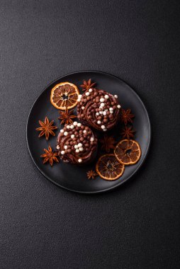 Doldurulmuş lezzetli taze kekler ve koyu beton arka planda çikolata kaplı.