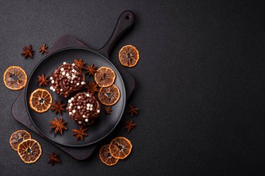 Doldurulmuş lezzetli taze kekler ve koyu beton arka planda çikolata kaplı.