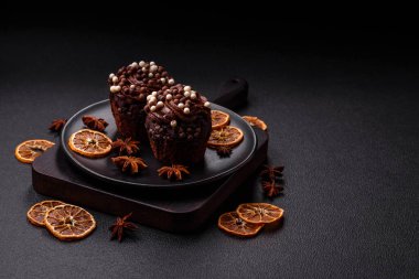 Doldurulmuş lezzetli taze kekler ve koyu beton arka planda çikolata kaplı.