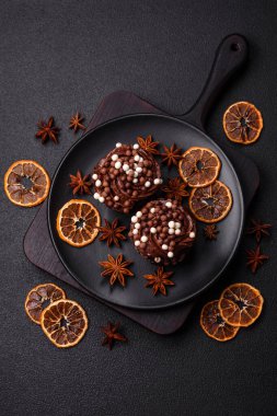 Doldurulmuş lezzetli taze kekler ve koyu beton arka planda çikolata kaplı.