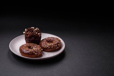 Doldurulmuş lezzetli taze çörekler ve koyu beton arka planda çikolata kaplı.