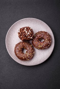 Doldurulmuş lezzetli taze çörekler ve koyu beton arka planda çikolata kaplı.