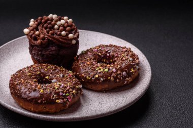 Doldurulmuş lezzetli taze çörekler ve koyu beton arka planda çikolata kaplı.