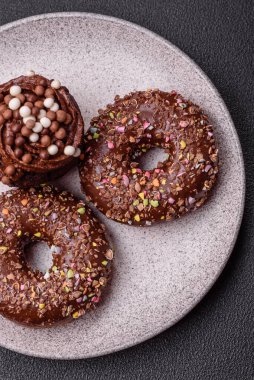 Doldurulmuş lezzetli taze çörekler ve koyu beton arka planda çikolata kaplı.