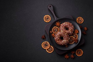 Doldurulmuş lezzetli taze çörekler ve koyu beton arka planda çikolata kaplı.