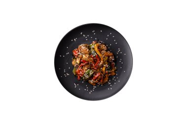 Baharatlı Asya yemeği dilimlenmiş et filetosu, acı biber, havuç ve susam tohumları koyu beton arka planda.