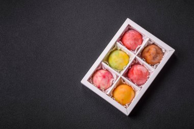 Lezzetli Asya mochi tatlısı pirinç hamuru kabuğu ve koyu beton arka planda meyveler.