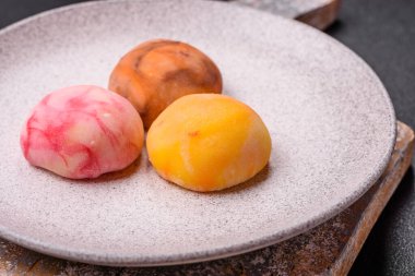 Lezzetli Asya mochi tatlısı pirinç hamuru kabuğu ve koyu beton arka planda meyveler.