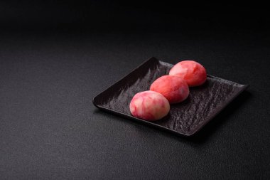 Lezzetli Asya mochi tatlısı pirinç hamuru kabuğu ve koyu beton arka planda meyveler.