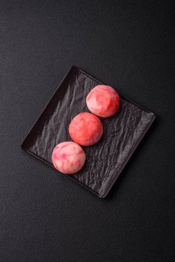 Lezzetli Asya mochi tatlısı pirinç hamuru kabuğu ve koyu beton arka planda meyveler.