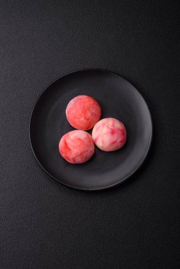 Lezzetli Asya mochi tatlısı pirinç hamuru kabuğu ve koyu beton arka planda meyveler.