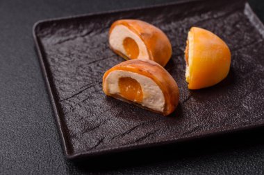 Lezzetli Asya mochi tatlısı pirinç hamuru kabuğu ve koyu beton arka planda meyveler.