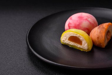 Lezzetli Asya mochi tatlısı pirinç hamuru kabuğu ve koyu beton arka planda meyveler.