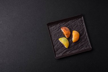 Lezzetli Asya mochi tatlısı pirinç hamuru kabuğu ve koyu beton arka planda meyveler.