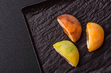 Lezzetli Asya mochi tatlısı pirinç hamuru kabuğu ve koyu beton arka planda meyveler.