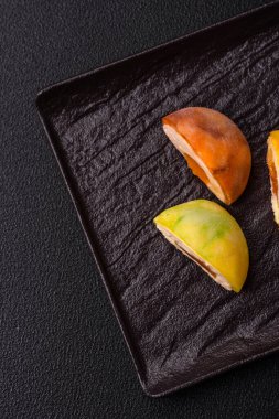 Lezzetli Asya mochi tatlısı pirinç hamuru kabuğu ve koyu beton arka planda meyveler.