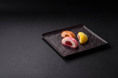 Lezzetli Asya mochi tatlısı pirinç hamuru kabuğu ve koyu beton arka planda meyveler.