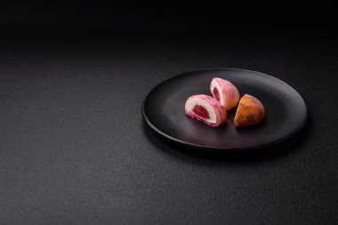 Lezzetli Asya mochi tatlısı pirinç hamuru kabuğu ve koyu beton arka planda meyveler.