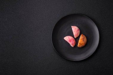 Lezzetli Asya mochi tatlısı pirinç hamuru kabuğu ve koyu beton arka planda meyveler.