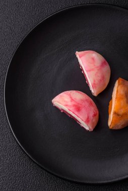 Lezzetli Asya mochi tatlısı pirinç hamuru kabuğu ve koyu beton arka planda meyveler.