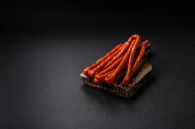 Koyu beton bir zeminde tuz ve baharatla tütsülenmiş mini sosis ya da kababanosi.