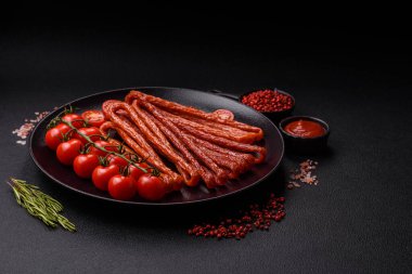 Koyu beton bir zeminde tuz ve baharatla tütsülenmiş mini sosis ya da kababanosi.