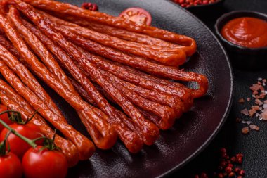 Koyu beton bir zeminde tuz ve baharatla tütsülenmiş mini sosis ya da kababanosi.