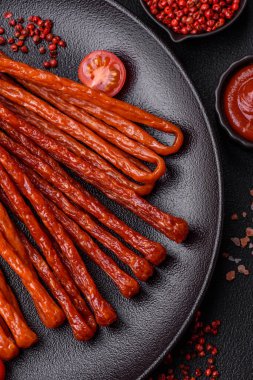 Koyu beton bir zeminde tuz ve baharatla tütsülenmiş mini sosis ya da kababanosi.