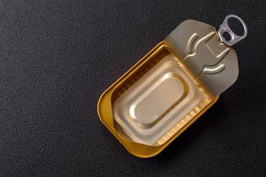 Teneke ya da alüminyum, koyu beton arka planda anahtarla konserve kutusunu açar.