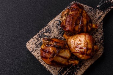Lezzetli ızgara tavuk bacağı. Baharatlı ve otlu teriyaki soslu. Koyu beton arka planda.
