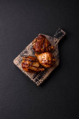 Lezzetli ızgara tavuk bacağı. Baharatlı ve otlu teriyaki soslu. Koyu beton arka planda.
