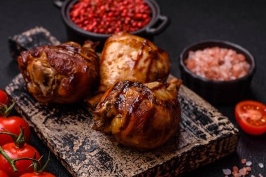 Lezzetli ızgara tavuk bacağı. Baharatlı ve otlu teriyaki soslu. Koyu beton arka planda.